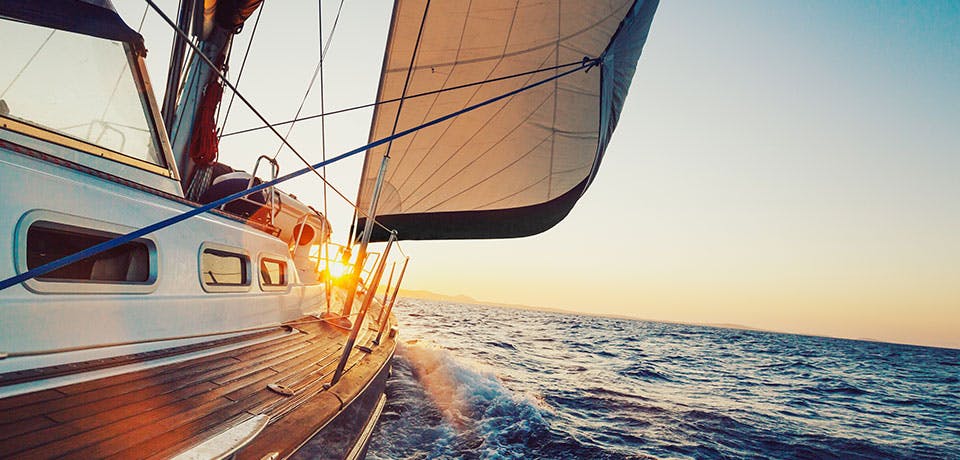 yacht sailing into sunset