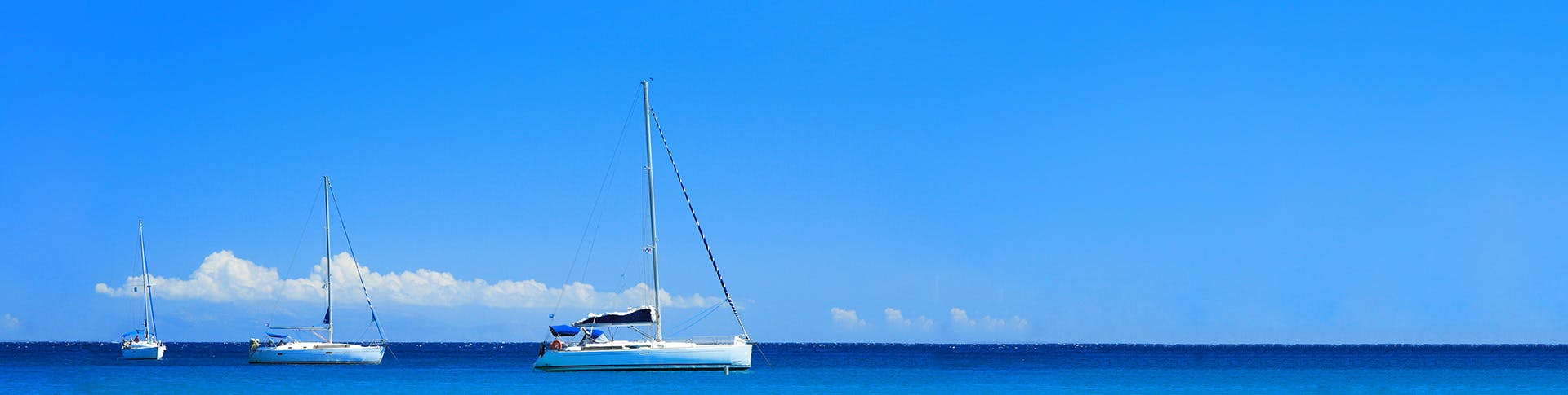 sailing yachts at anchor in a blue lagoon