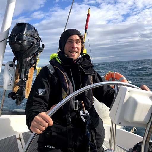 Simon steering a sailing yacht